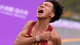 (FILES) This file photo taken on October 5, 2023 shows China's He Jie celebrating after crossing the finish line to win the men's marathon final athletics event during the 2022 Asian Games in Hangzhou in China's eastern Zhejiang province.  The booming popularity of road running in China has 