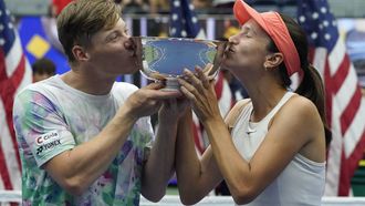 2023-09-09 18:33:57 Kazakhstan's Anna Danilina (R) and Finland's Harri Heliovaara kiss their trophy after defeating USA's Jessica Pegula and Austin Krajicek during the US Open tennis tournament mixed doubles final match at the USTA Billie Jean King National Tennis Center in New York City, on September 9, 2023. 
TIMOTHY A. CLARY / AFP