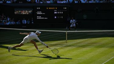 Italy's Jannik Sinner misses his return to Serbia's Novak Djokovic during their men's singles semi-final tennis match on the twelfth day of the 2025 Wimbledon Championships at The All England Lawn Tennis and Croquet Club in Wimbledon, southwest London, on July 11, 2025. 
Glyn KIRK / AFP