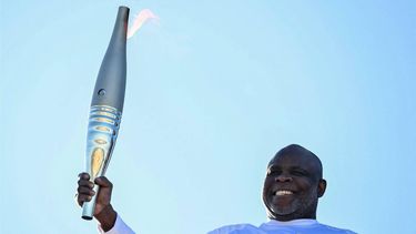 French former football player Basile Boli holds the Olympic Torch as part of the Olympic and Paralympic Torch Relays at the Notre Dame de la Garde Basilica, ahead of the Paris 2024 Olympic and Paralympic Games, in Marseille, southeastern France, on May 9, 2024. The transfer of the flame onshore from a 19th-century tall ship will mark the start of a 12,000-kilometre (7,500-mile) torch relay across mainland France and the country's far-flung overseas territories.
CHRISTOPHE SIMON / AFP