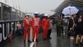 epa13280095 Safety officials stands on the wet grid as heavy rain delays the start of the 2026 Formula 1 Bahrain Grand Prix at the Sepang International Circuit in Malaysia, in Sepang, Malaysia, 04 October 2026.  EPA/FAZRY ISMAIL
