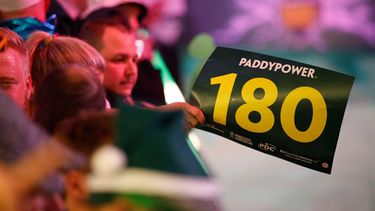 epa11779768 A fan waves a '180' placard during the opening session of the Paddy Power World Darts Championship at Alexandra Palace in London, Britain 15 December 2024.  EPA/DAVID CLIFF
