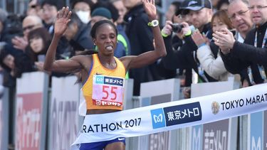 Kenya's Sarah Chepchirchir (C, #55) crosses the finish line in the women's category of the Tokyo Marathon in Tokyo on February 26, 2017. 
KAZUHIRO NOGI / AFP