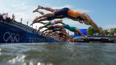 Athletes dive into the Seine river to start the swimming stage of the men's individual triathlon at the Paris 2024 Olympic Games in central Paris on July 31, 2024. 
David Goldman / POOL / AFP