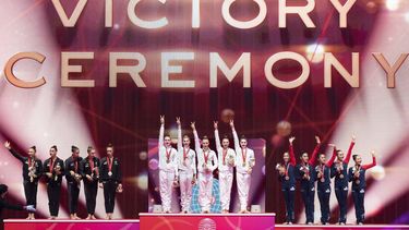 (L-R) Silver medallists team Italy, gold medallists team Russia and bronze medallists team Japan pose on the podium after the group five balls final during the Rhythmic Gymnastics World Championships at the West Japan General Exhibition Centre in Kitakyushu, Fukuoka prefecture on October 31, 2021. 
Charly TRIBALLEAU / AFP