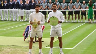 2023-07-16 20:11:53 Spain's Carlos Alcaraz (L) holds the winner's trophy as he poses with Serbia's Novak Djokovic after their men's singles final tennis match on the last day of the 2023 Wimbledon Championships at The All England Tennis Club in Wimbledon, southwest London, on July 16, 2023.  
Glyn KIRK / AFP