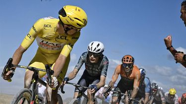 UAE Team Emirates team's Slovenian rider Tadej Pogacar wearing the overall leader's yellow jersey looks back as he cycles ahead of Team Visma - Lease a Bike team's Danish rider Jonas Vingegaard (2nd L) over a 
