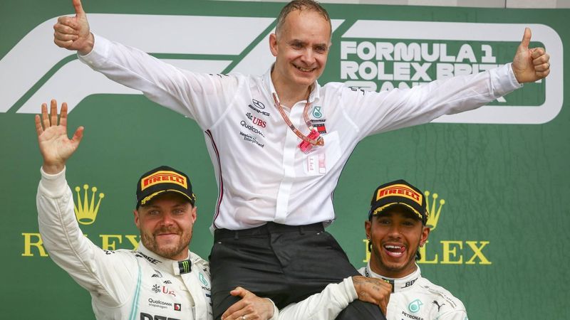 epa07716927 British Formula One driver Lewis Hamilton of Mercedes AMG GP (R) celebrates winning the Formula One Grand Prix of Great Britain with John Owen (head of design at Mercedes AMG) and Finnish Formula One driver Valtteri Bottas of Mercedes AMG GP (L) at the Silverstone circuit, in Northamptonshire, Britain, 14 July 2019.  EPA/GEOFF CADDICK