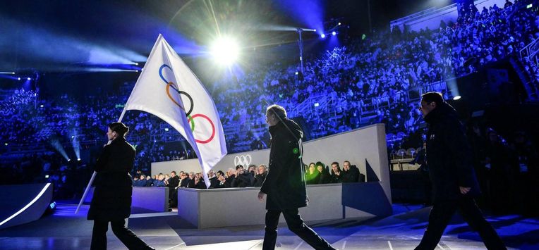Milan mayor Giuseppe Sala (C) and Cortina d'Ampezzo mayor Gianluca Lorenzi (R) walk behind the Olympic flag during the flag handover ceremony at the closing ceremony of the Milano Cortina 2026 Winter Olympic Games at the Verona Arena in Verona, northern Italy, on February 22, 2026. 
Stefano RELLANDINI / AFP