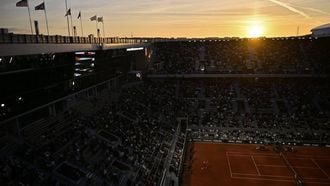 This general view shows the sunset over Denmark's Holger Rune playing a forehand return to US Emilio Nava during their men's singles match on day 4 of the French Open tennis tournament on Court Philippe-Chatrier at the Roland-Garros Complex in Paris on May 28, 2025. 
JULIEN DE ROSA / AFP