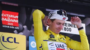 UAE Team Emirates XRG's Slovenian rider Tadej Pogačar celebrates wearing the overall leader's yellow jersey on the podium of the 7th stage of the 77th edition of the Criterium du Dauphine cycling race, 131,6 km between Grand-Aigueblanche and Valmeinier, on June 14, 2025. 
Anne-Christine POUJOULAT / AFP