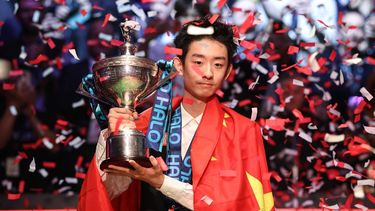 China's Wu Yize poses with the championship trophy after his victory over England's Shaun Murphy in the World Snooker Championship final round at The Crucible in Sheffield, northern England on May 4, 2026.  
Darren Staples / AFP