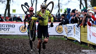Belgium's Wout van Aert (front) carries his bike as he competes in the men's elite Superprestige cyclocross cycling race, in Gullegem on January 4, 2025. 
DAVID PINTENS / Belga / AFP