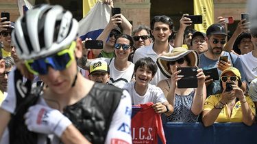 Spectators cheer and take photographs as UAE Team Emirates team's Slovenian rider Tadej Pogacar (L) adjusts his ear-piece at the start of the 1st stage of the 111th edition of the Tour de France cycling race, 206 km between Florence and Rimini, in Italy, on June 29, 2024. 
Marco BERTORELLO / AFP