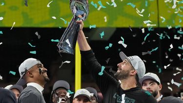 Philadelphia Eagles' quarterback #01 Jalen Hurts smiles as Philadelphia Eagles' head coach Nick Sirianni holds up the Lombardi trophy after they defeated the Kansas City Chiefs 40-22 in Super Bowl LIX at Caesars Superdome in New Orleans, Louisiana, February 9, 2025. 
TIMOTHY A. CLARY / AFP