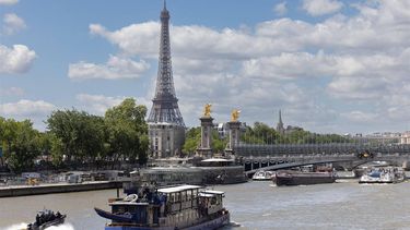 A Paris police (DOPC) boat (bottom L) makes its way past a cruise boat along the Seine River in Paris on July 4, 2024. 
JOEL SAGET / AFP