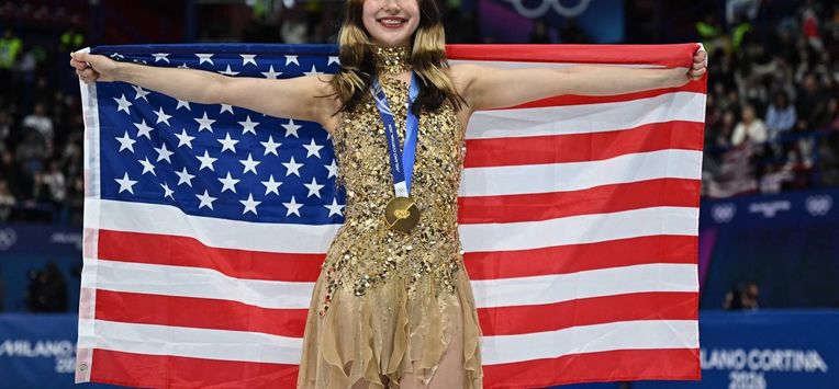 Gold medallist USA's Alysa Liu holds her country's flag after the victory ceremony of the figure skating women's single free skating final during the Milano Cortina 2026 Winter Olympic Games at Milano Ice Skating Arena in Milan on February 19, 2026. 
Gabriel BOUYS / AFP