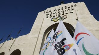 epa12084083 LA28 flags are displayed ahead of a news conference to announce that the Los Angeles Memorial Coliseum and the SoFi Stadium will serve as the official venues for the Opening and Closing Ceremonies of the 2028 Olympic and Paralympic Games, at the Los Angeles Memorial Coliseum in Los Angeles, California, USA, 08 May 2025.  EPA/CAROLINE BREHMAN