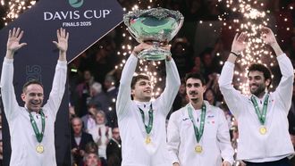 Italy's Flavio Cobolli (C), next to Italy's team captain Filippo Volandri (L) and Italy's Matteo Berrettini (R), lifts the David Cup trophy after their victory over Spain in their 2025 Davis Cup men's single final tennis match at the Super Tennis Arena in Bologna, northen Italy, on November 23, 2025. 
Tiziana FABI / AFP