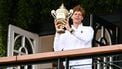 Italy's Jannik Sinner celebrates with the winner's trophy as he shows it to the crowd from the Centre Court balcony following his victory against Spain's Carlos Alcaraz at the end of their men's singles final tennis match on the fourteenth day of the 2025 Wimbledon Championships at The All England Lawn Tennis and Croquet Club in Wimbledon, southwest London, on July 13, 2025. 
Kirill KUDRYAVTSEV / AFP