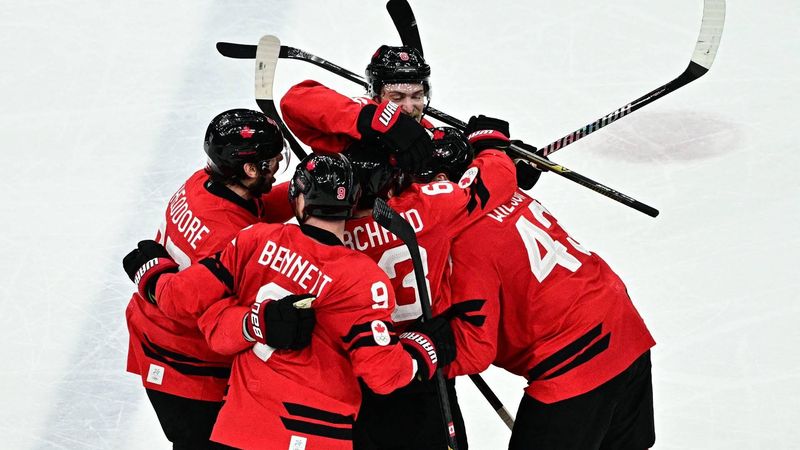 Canada's #27 Shea Theodore (L) celebrates with teammates after scoring his team's second goal during the men's play-off semi-final ice hockey match between Canada and Finland at the Milano Santagiulia Ice Hockey Arena during the Milano Cortina 2026 Winter Olympic Games in Milan, on February 20, 2026. 
JULIEN DE ROSA / AFP