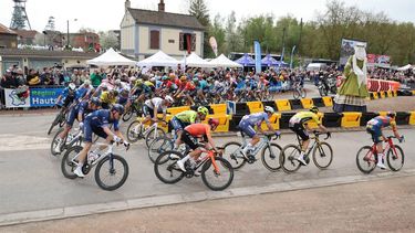 The pack of riders cycle around the new controversial chicane erected to reduce speed and mitigate crash risk at the entrance of 
