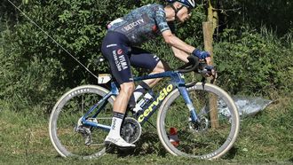 Team Visma - Lease a Bike team's Danish rider Jonas Vingegaard cycles with the bicycle belonging to teammate Slovenian rider Jan Tratnik, after trading bicycles following a mechanical failure, as he cycles over a 