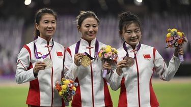 This photo taken on October 4, 2023 shows (L-R) silver medallist China's Liu Hong, gold medallist China's Qieyang Shijie, and bronze medallist China's Lu Xiuzhi celebrating on the podium during a medal reallocation ceremony to award the three athletes with their belated 2012 London Summer Olympics medals, on the sidelines of the 2022 Asian Games in Hangzhou in China's eastern Zhejiang province. The Chinese race walkers received their medals after the initial gold and silver medallists have been disqualified for violating anti-doping rules. 
JUNG Yeon-je / AFP