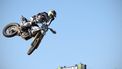 Netherland's Kay De Wolf rips of a visor as he takes a jump during the first race of the MX2 class during the motorcross MXGP of Great Britain at Matterley Basin in Winchester, southern England on February 27, 2022. 
ADRIAN DENNIS / AFP