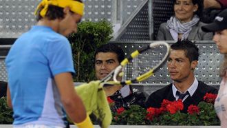 Madrid's Portuguese forward Cristiano Ronaldo (R) and unidentified friend watch the match between Spanish Rafael Nadal (L) and US John Isner at the Madrid Masters on May 13, 2010 at the Caja Magic sports complex in Madrid. AFP PHOTO / DOMINIQUE FAGET
DOMINIQUE FAGET / AFP