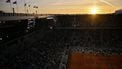 This general view shows the sunset over Denmark's Holger Rune playing a forehand return to US Emilio Nava during their men's singles match on day 4 of the French Open tennis tournament on Court Philippe-Chatrier at the Roland-Garros Complex in Paris on May 28, 2025. 
JULIEN DE ROSA / AFP