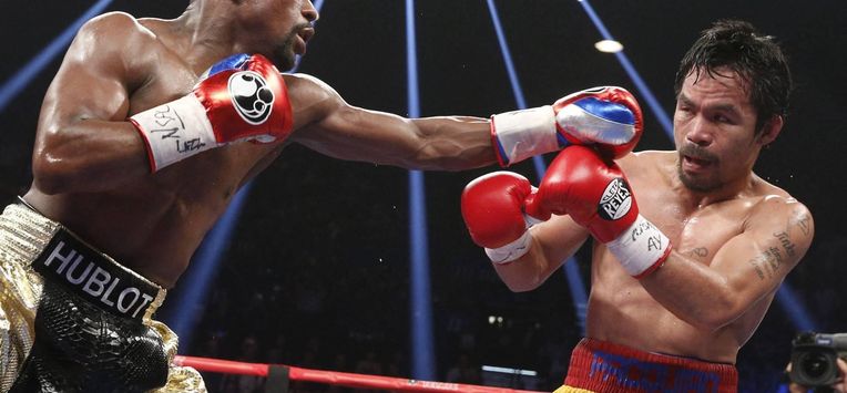 Floyd Mayweather Jr. exchange punches with Manny Pacquiao during their welterweight unification championship bout, May 2, 2015 at MGM Grand Garden Arena in Las Vegas, Nevada.  Mayweather defeated Pacquiao by unanimous decision.  AFP PHOTO / JOHN GURZINKSI 
JOHN GURZINSKI / AFP