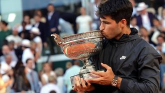 epa11400511 Carlos Alcaraz of Spain kisses the Coupe des Mousquetaires trophy after winning his Men’s Singles final match against Alexander Zverev of Germany during the French Open Grand Slam tennis tournament at Roland Garros in Paris, France, 09 June 2024.  EPA/TERESA SUAREZ