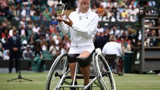 Netherlands' Diede De Groot poses with the winner's trophy after beating Netherlands' Aniek Van Koot in the women's wheelchair singles final tennis match on the thirteens day of the 2024 Wimbledon Championships at The All England Lawn Tennis and Croquet Club in Wimbledon, southwest London, on July 13, 2024. De Groot won the match 6-4, 6-4.
HENRY NICHOLLS / AFP