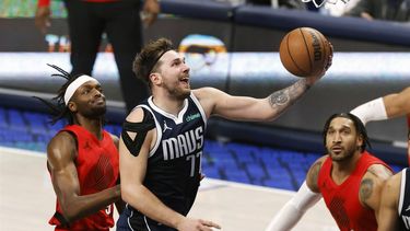 epa11056141 Dallas Mavericks guard Luka Doncic of Slovenia (R) makes a layup past Portland Trail Blazers forward Jerami Grant (L) during the second half of the NBA basketball game between the Dallas Mavericks and the Portland Trail Blazers in Dallas, Texas, USA, 03 January 2024.  EPA/ADAM DAVIS SHUTTERSTOCK OUT