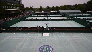 Outer courts are covered after a persistent rain started and stopped all outdoor play on day four of the 2013 Wimbledon Championships tennis tournament at the All England Club in Wimbledon, southwest London, on June 27, 2013. Rain forced the abandonment of play at Wimbledon on June 27 apart from centre court where they deployed the roof. AFP PHOTO / CARL COURT -  RESTRICTED TO EDITORIAL USE
CARL COURT / AFP