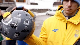Ukraine's skeleton racer Vladyslav Heraskevych holds his helmet, which depicts victims of his country's war with Russia, in Cortina d'Ampezzo on February 12, 2026. Heraskevych was disqualified from the Winter Olympics on February 12, 2026 after refusing to back down over his banned helmet, which depicts victims of his country's war with Russia.
The International Olympic Committee said he had been kicked out of the Milan-Cortina Games 