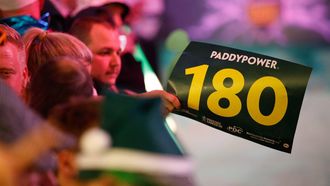 epa11779768 A fan waves a '180' placard during the opening session of the Paddy Power World Darts Championship at Alexandra Palace in London, Britain 15 December 2024.  EPA/DAVID CLIFF