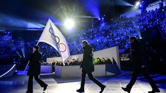 Milan mayor Giuseppe Sala (C) and Cortina d'Ampezzo mayor Gianluca Lorenzi (R) walk behind the Olympic flag during the flag handover ceremony at the closing ceremony of the Milano Cortina 2026 Winter Olympic Games at the Verona Arena in Verona, northern Italy, on February 22, 2026. 
Stefano RELLANDINI / AFP
