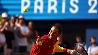 epa11503378 Rafael Nadal of Spain shoots signd tennis balls into the stands after his win in the Men's Singles first round match against Marton Fucsovics of Hungary at the Tennis competitions in the Paris 2024 Olympic Games, at the Roland Garros in Paris, France, 28 July 2024.  EPA/DIVYAKANT SOLANKI