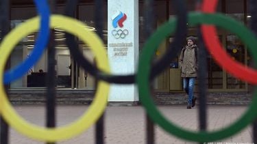 A man walks past the logo of the Russian Olympic Committee (ROC) as he leaves the office in Moscow on October 15, 2024. The head of Russia's Olympic Committee announced his resignation on October 15, 2024, a surprise move that comes as Moscow faces isolation from international sport over its Ukraine offensive. Former fencer, Stanislav Pozdnyakov, a five-time Olympic medallist, said in his resignation letter there were 