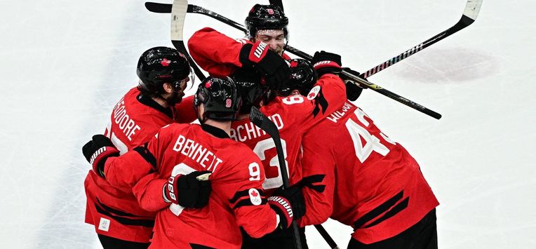 Canada's #27 Shea Theodore (L) celebrates with teammates after scoring his team's second goal during the men's play-off semi-final ice hockey match between Canada and Finland at the Milano Santagiulia Ice Hockey Arena during the Milano Cortina 2026 Winter Olympic Games in Milan, on February 20, 2026. 
JULIEN DE ROSA / AFP