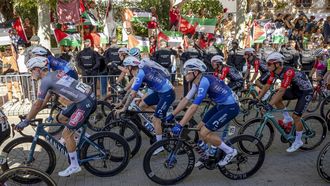 epa12376526 Demonstrators, some holding Palestinian flags, protest as some members of Israel-Premier Tech team pass by during the 21st and last stage of La Vuelta a Espana cycling race, a 103.6 km race between Alalpardo and Madrid, in Madrid, Spain, 14 September 2025.  EPA/Daniel Gonzalez