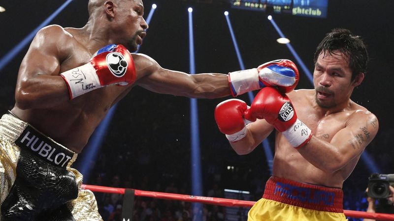 Floyd Mayweather Jr. exchange punches with Manny Pacquiao during their welterweight unification championship bout, May 2, 2015 at MGM Grand Garden Arena in Las Vegas, Nevada.  Mayweather defeated Pacquiao by unanimous decision.  AFP PHOTO / JOHN GURZINKSI 
JOHN GURZINSKI / AFP
