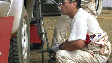 BAM14 - 20000108 - BAMAKO, MALI : Japanese driver Kenjiro Shinozuka looks at one of his tyres after a puncture 08 January 2000 in the savannah during the third leg of the 22nd Paris-Dakar-Cairo rally between Kayes and Bamako (Mali). Shinozuka won the stage and remains leader in the general classification. (ELECTRONIC IMAGE)EPA PHOTO AFP/PATRICK HERTZOG/ph/sc/emp