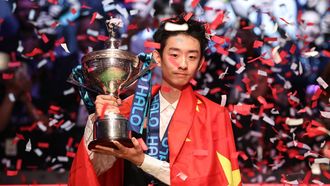 China's Wu Yize poses with the championship trophy after his victory over England's Shaun Murphy in the World Snooker Championship final round at The Crucible in Sheffield, northern England on May 4, 2026.  
Darren Staples / AFP