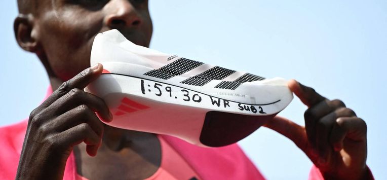 Kenya's Sabastian Sawe poses with his new world record time written on his running shoe at the finish of the 2026 London Marathon in central London on April 26, 2026. Kenya's Sabastian Sawe broke the two-hour mark for the first time in history on Sunday in winning the London Marathon.
JUSTIN TALLIS / AFP