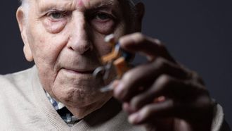 Olympic champion in Men's Team Pursuit in track cycling at the 1948 London Games, Charles Coste, poses with a cyclist figurine during a photo session at home in Bois-Colombes, northwestern of Paris, on January 30, 2024.  Charles Coste is the oldest living French Olympic champion.
JOEL SAGET / AFP