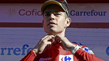 New leader of the general ranking Team Visma's Wout van Aert puts on the leader's Red Jersey on the podium after the stage 2 of La Vuelta a Espana cycling tour, a 194 km race between Cascais and Ourem, on August 18, 2024.   
MIGUEL RIOPA / AFP