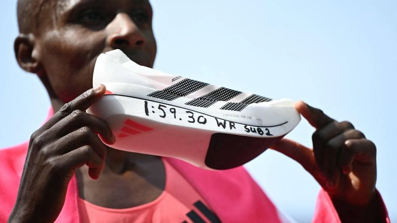 Kenya's Sabastian Sawe poses with his new world record time written on his running shoe at the finish of the 2026 London Marathon in central London on April 26, 2026. Kenya's Sabastian Sawe broke the two-hour mark for the first time in history on Sunday in winning the London Marathon.
JUSTIN TALLIS / AFP
